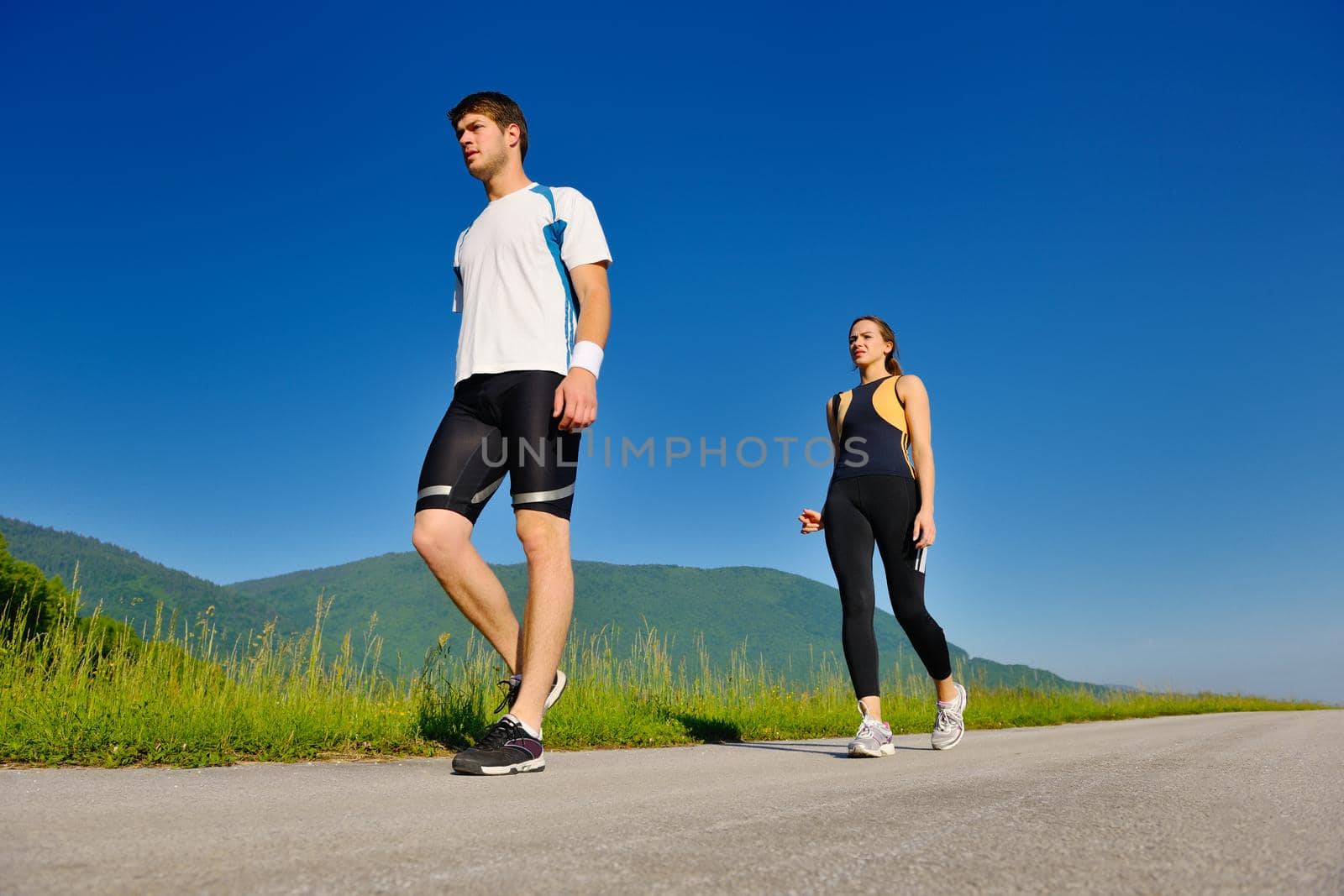 Young couple jogging in park at morning. Health and fitness.