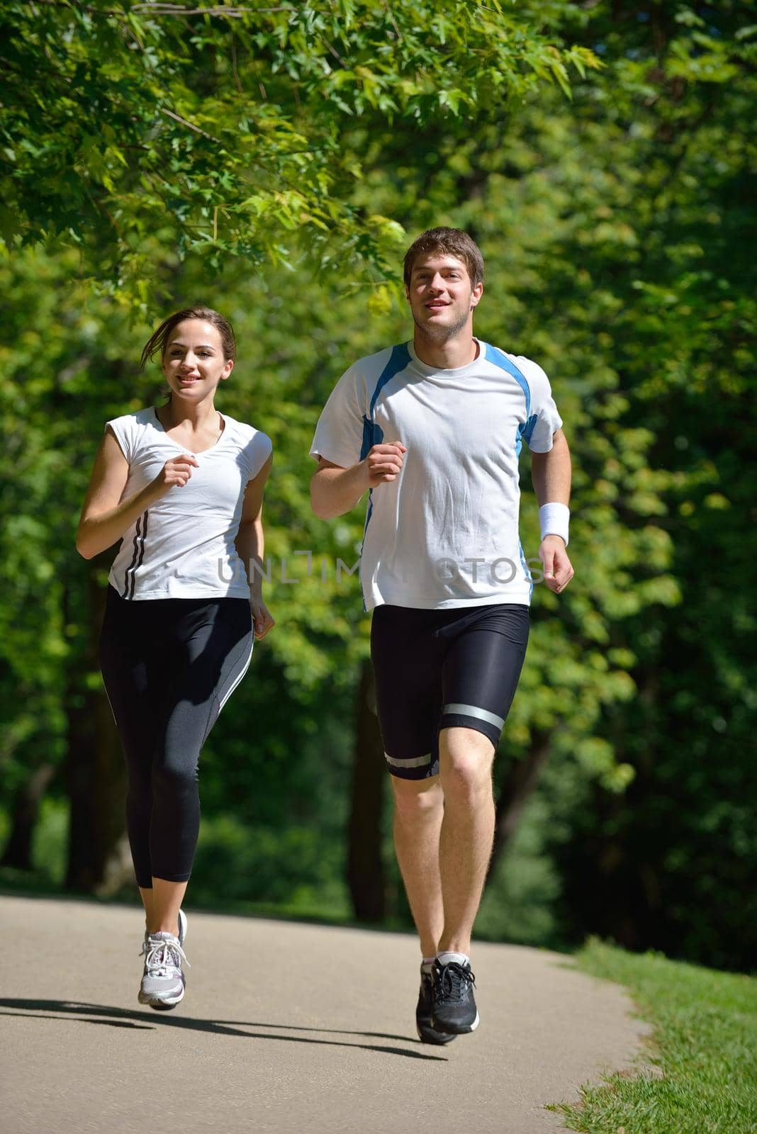 Young couple jogging in park at morning. Health and fitness concept