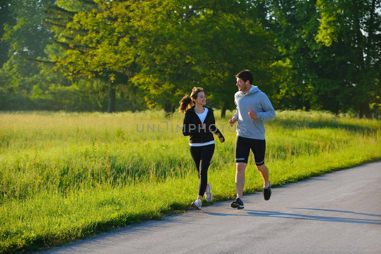 Young couple jogging in park at morning. Health and fitness.