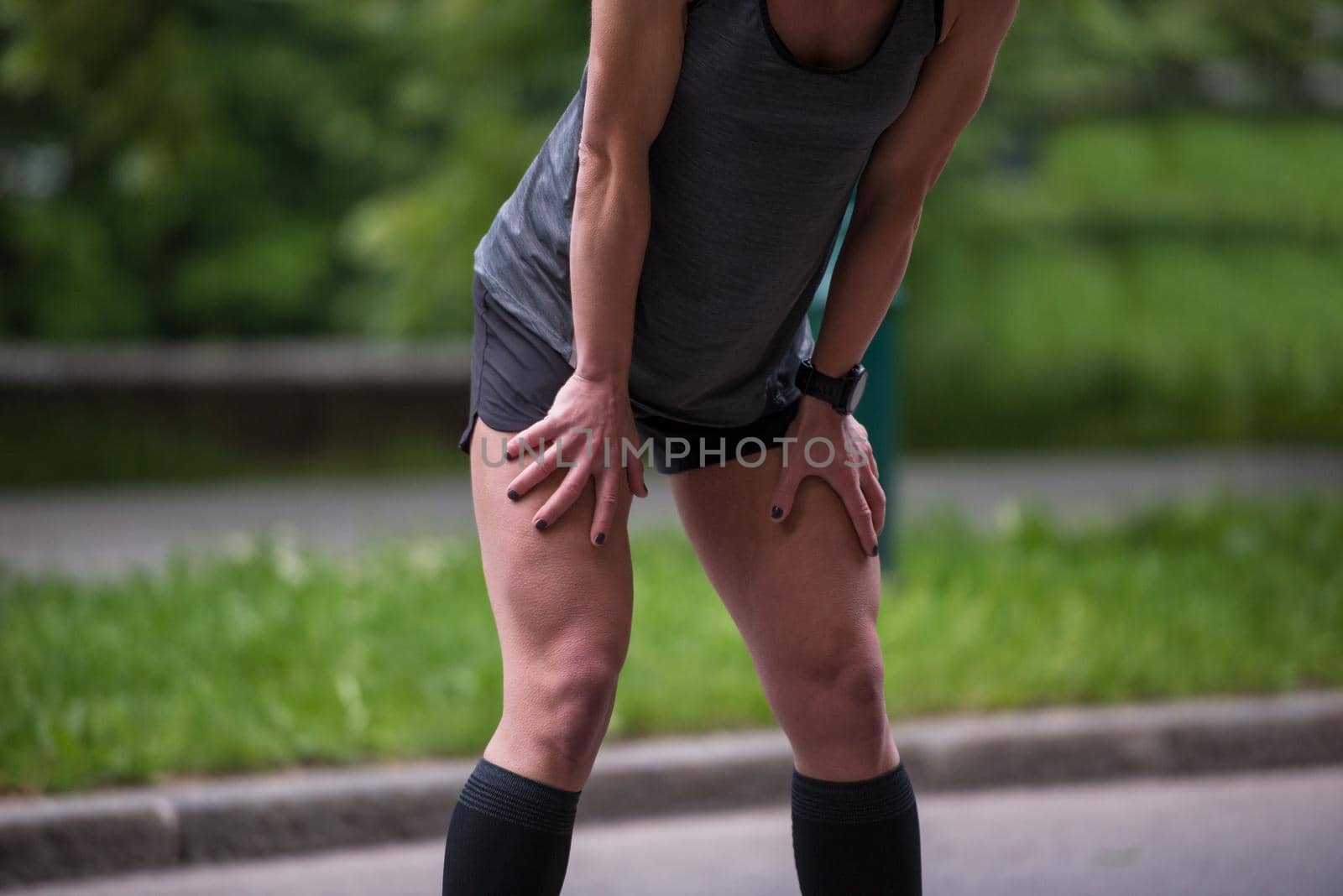 female runner warming up and stretching before morning training by dotshock