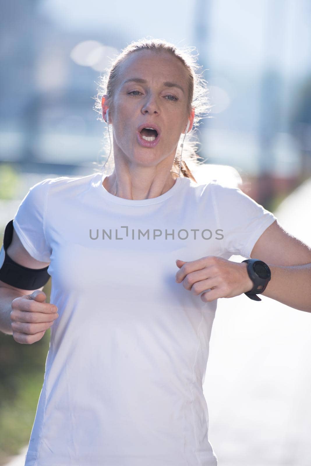 sporty woman running  at early morning with city  sunrise scene in background