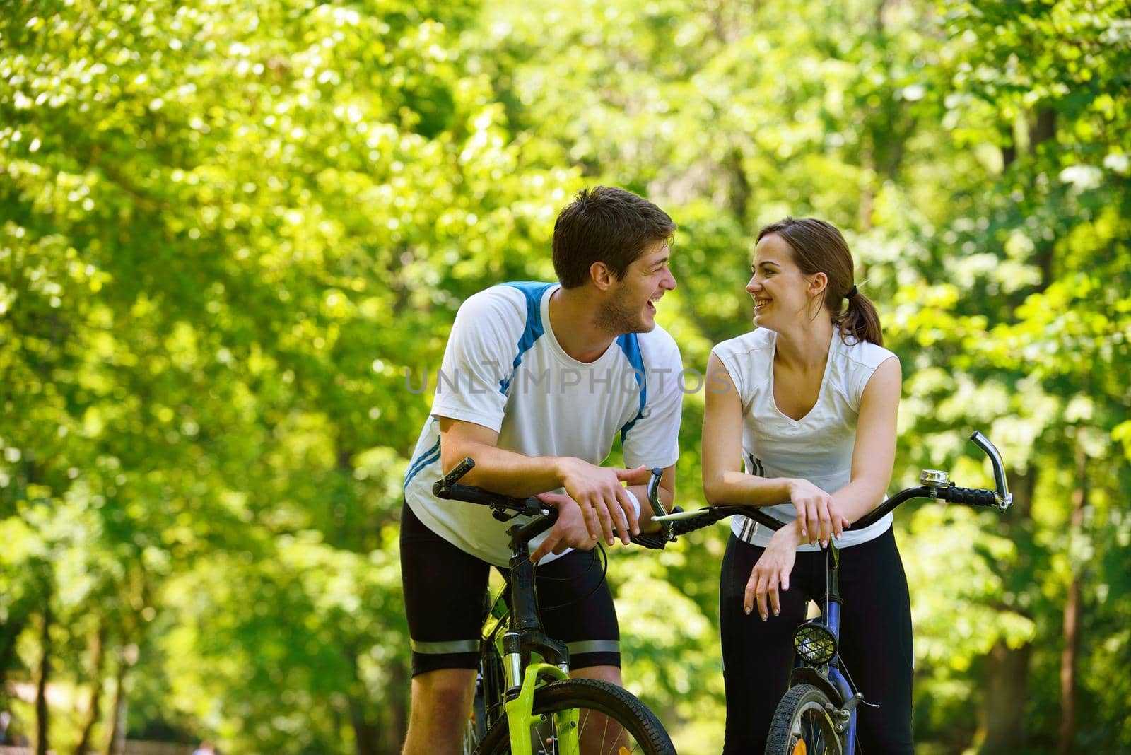 Happy couple ride bicycle outdoors, health lifestyle fun love romance concept