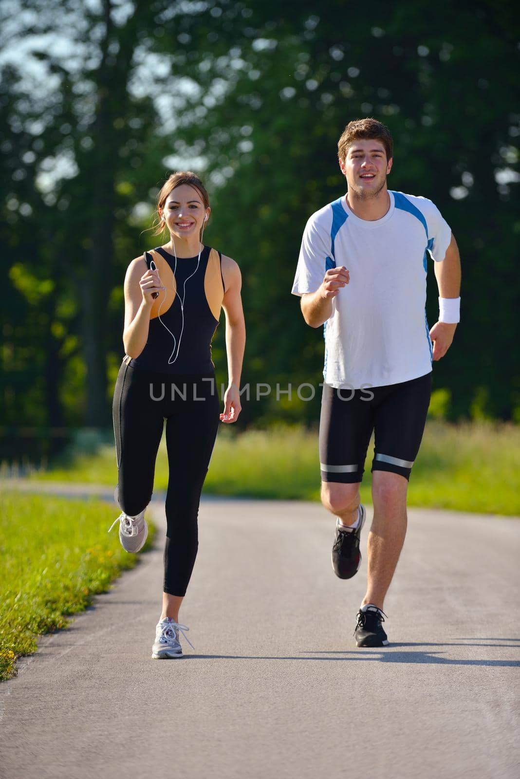 Young couple jogging in park at morning. Health and fitness.