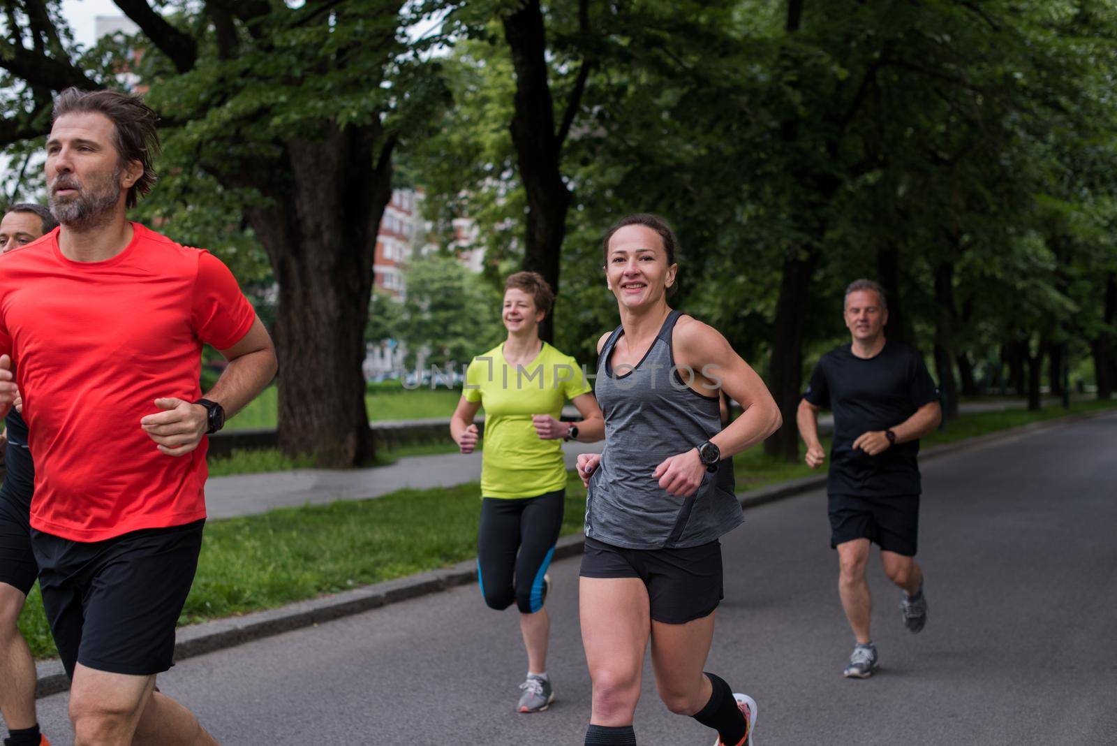 group of healthy people jogging in city park, runners team on morning training