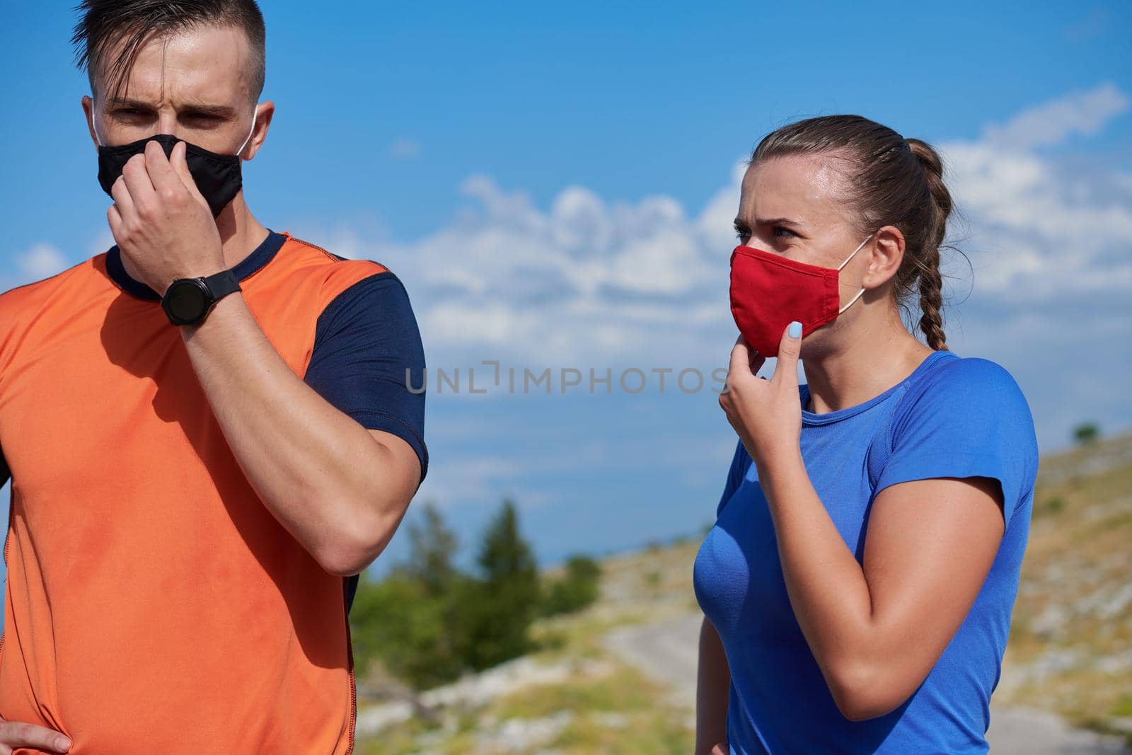 couple of running in nature wearing mask having a break by dotshock