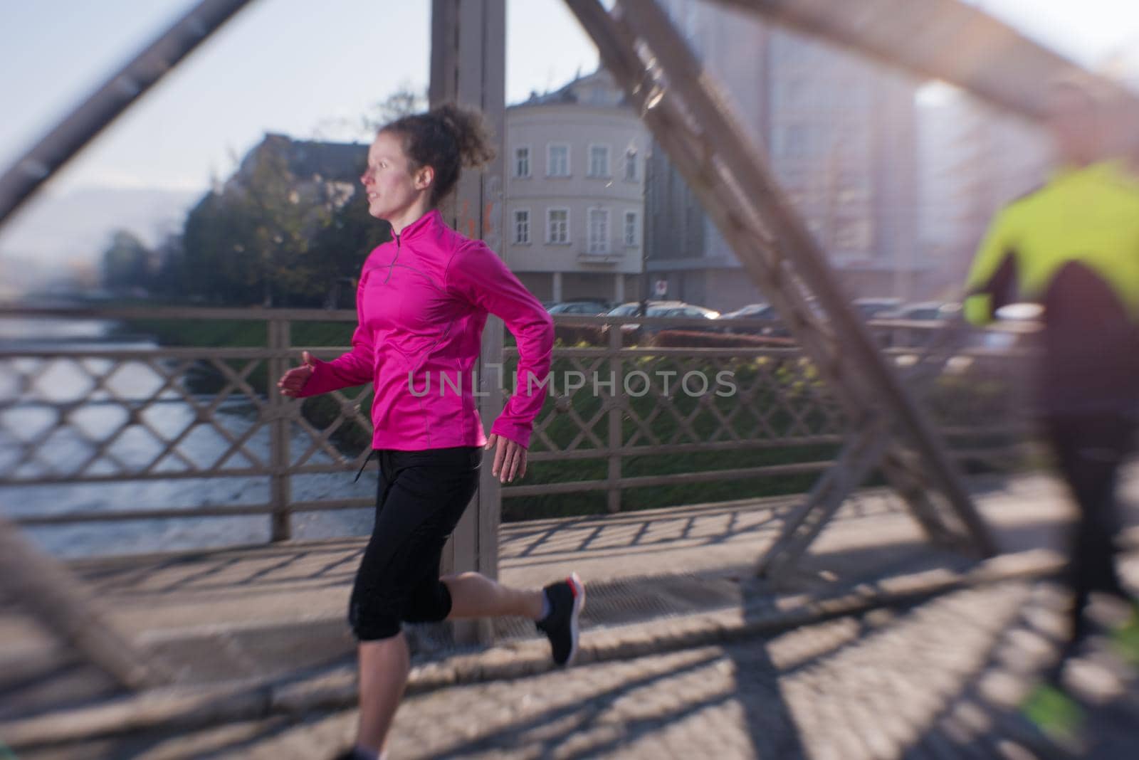 healthy young  couple jogging in the city  at early morning with sunrise in background