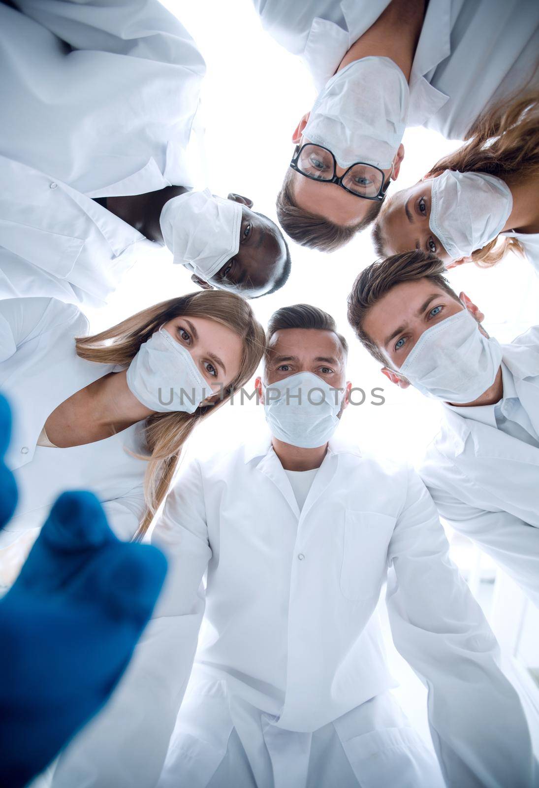 Surgeons in operating theatre looking down at patient, personal perspective