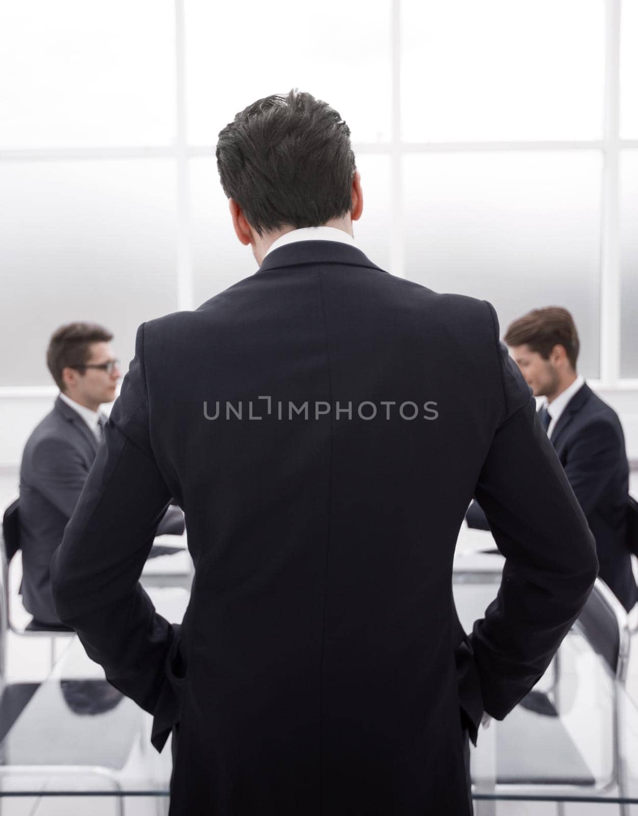 rear view.businessman standing in the conference room by asdf