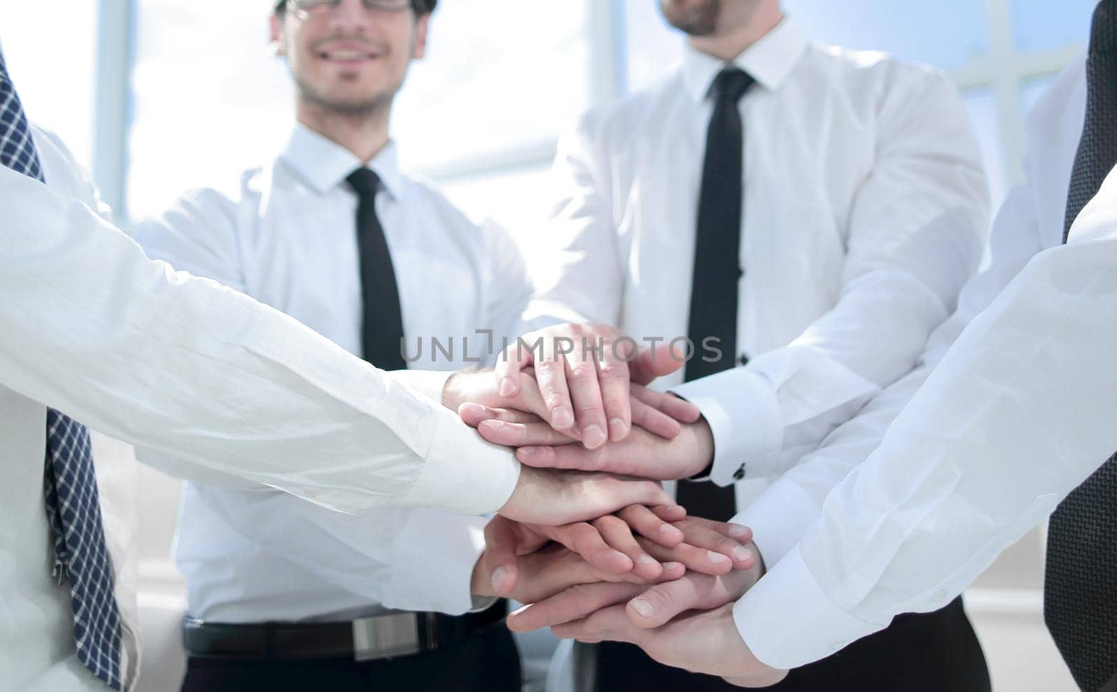 professional business team folding their hands together by asdf