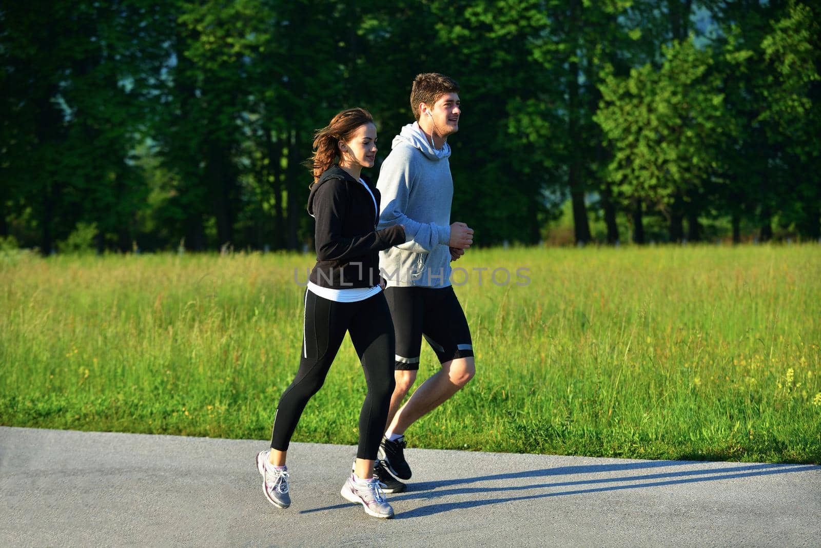 Young couple jogging in park at morning. Health and fitness.