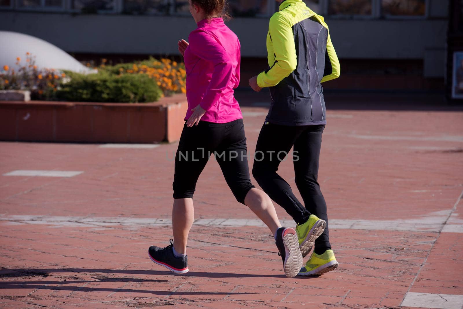 healthy young  couple jogging in the city  at early morning with sunrise in background