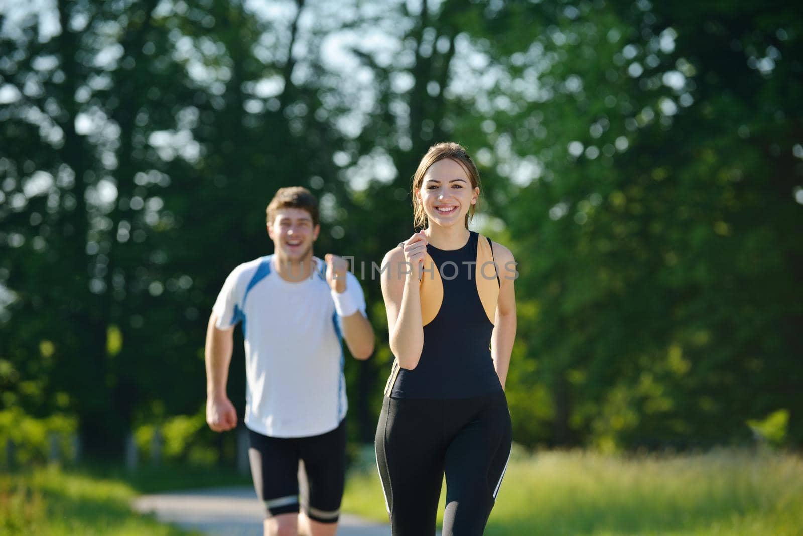 Young couple jogging in park at morning. Health and fitness concept