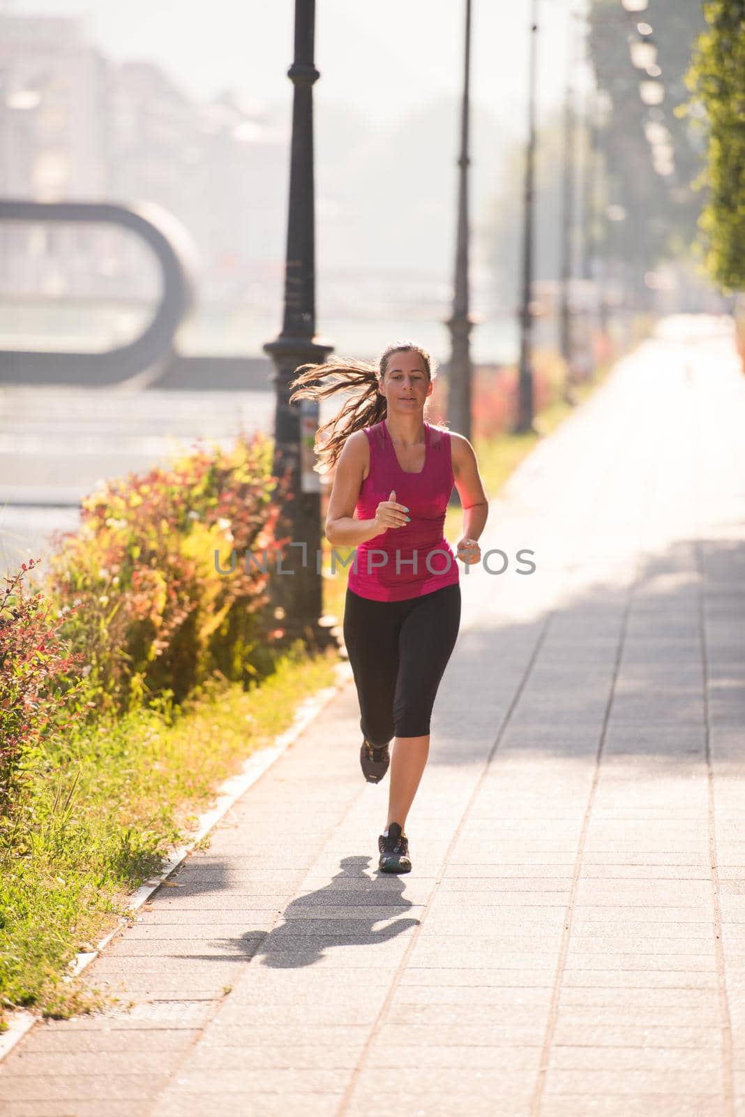 woman jogging at sunny morning by dotshock