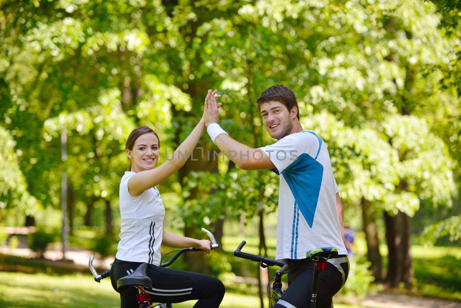 Happy couple riding bicycle outdoors, health lifestyle fun love romance concept