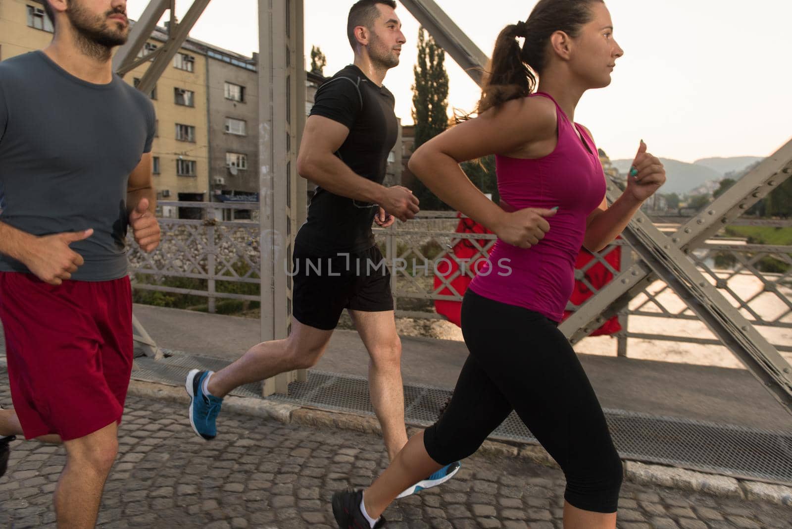 group of young people jogging across the bridge by dotshock