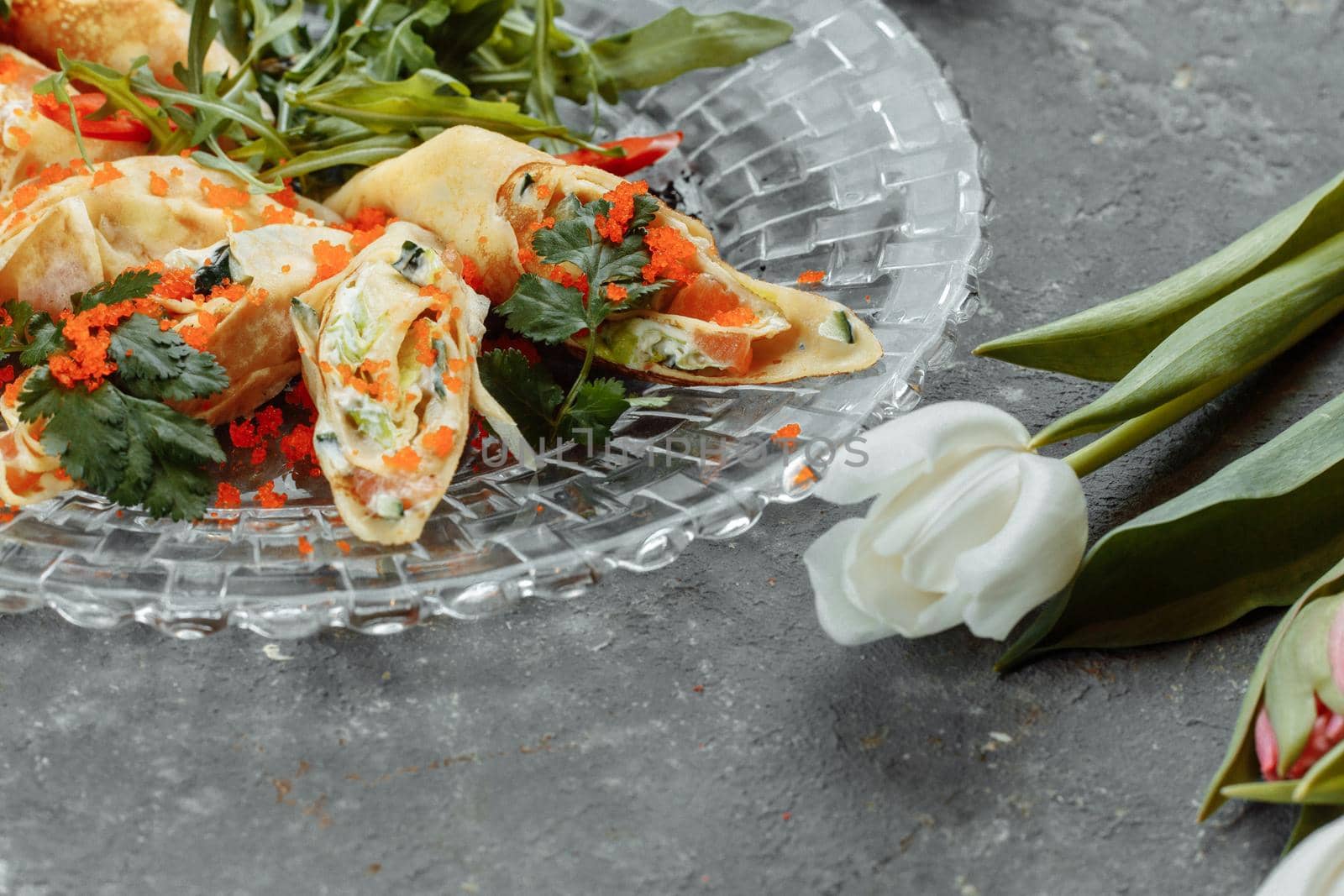 thin pancakes with caviar and salmon, rolled into rolls.