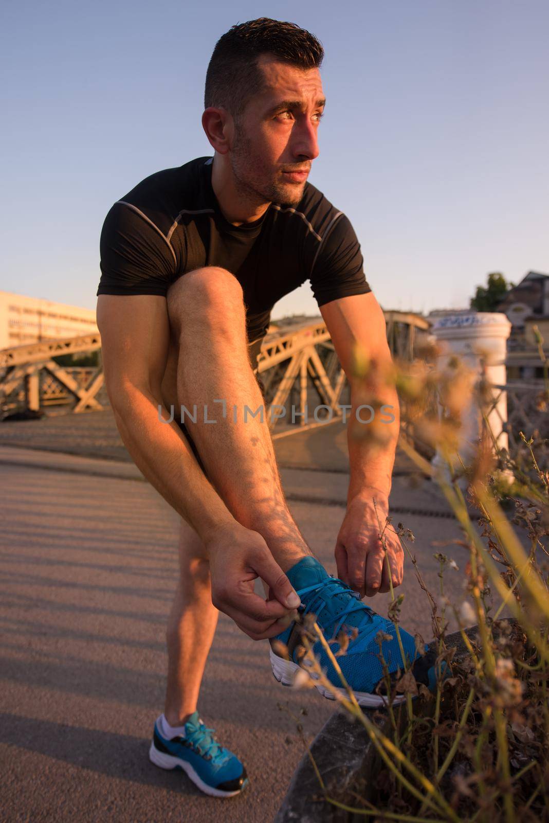 man tying running shoes laces by dotshock