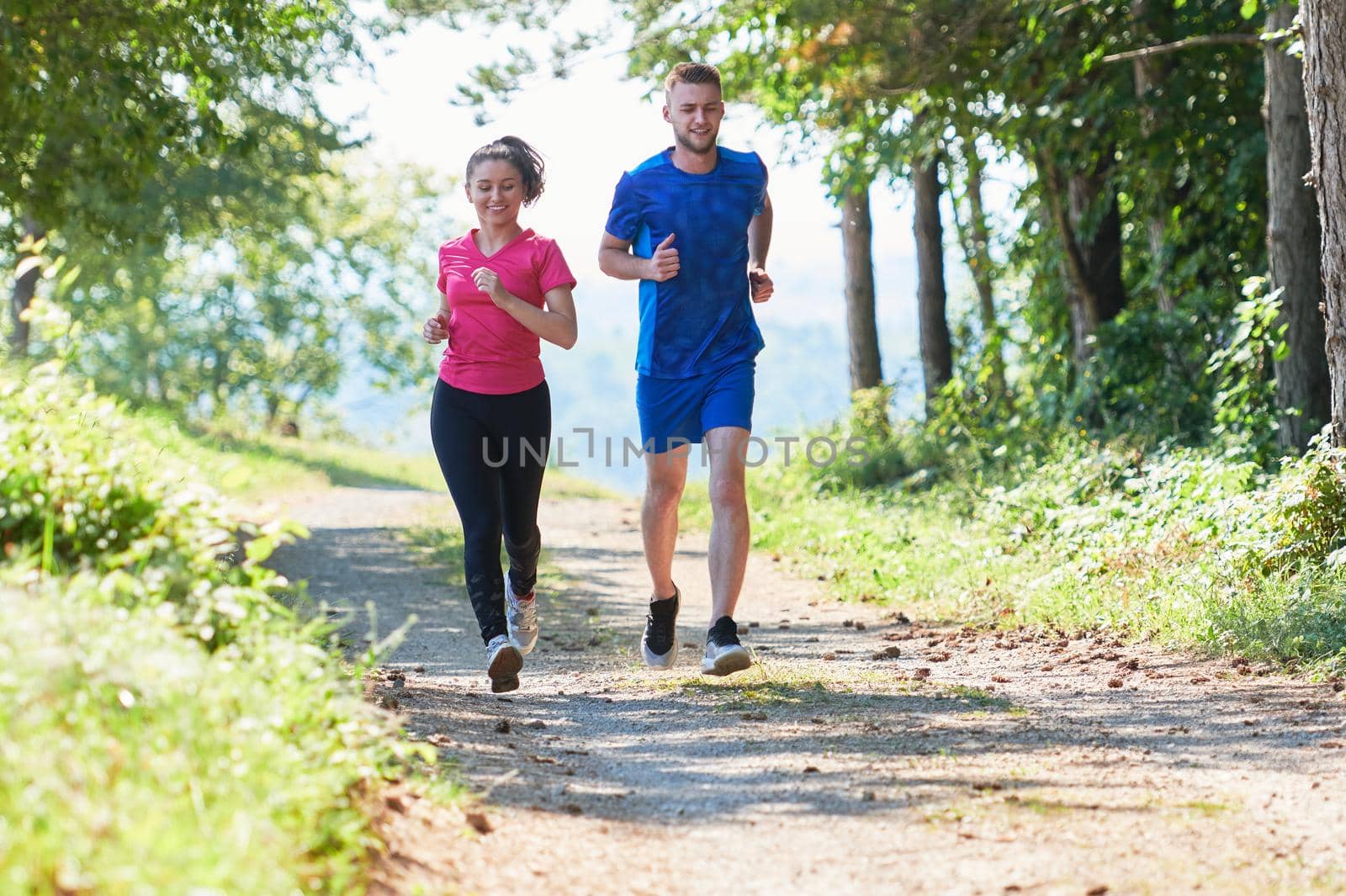 couple enjoying in a healthy lifestyle while jogging on a country road by dotshock