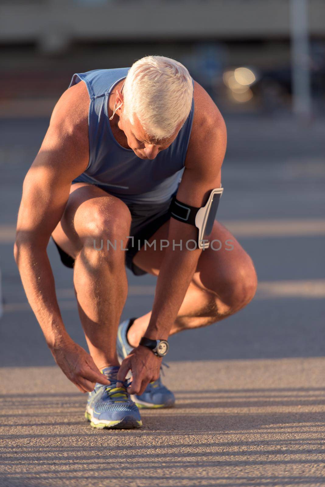 Man tying running shoes laces  before jogging workout