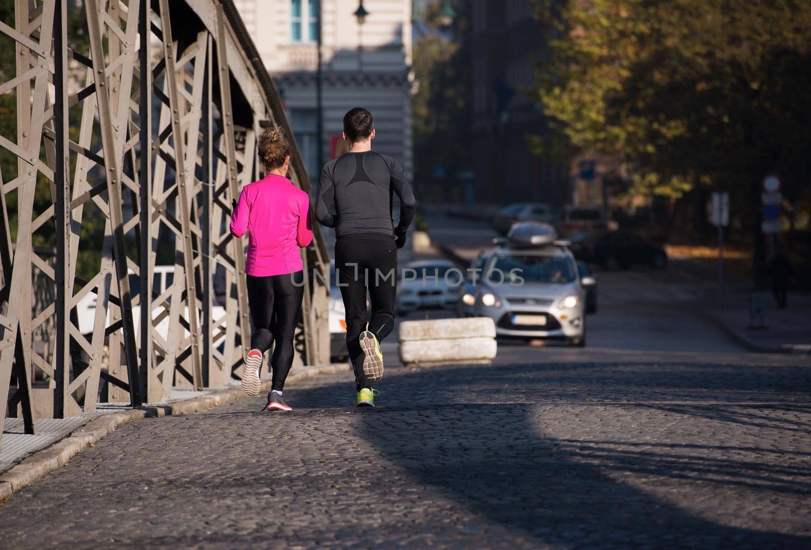 healthy young  couple jogging in the city  at early morning with sunrise in background