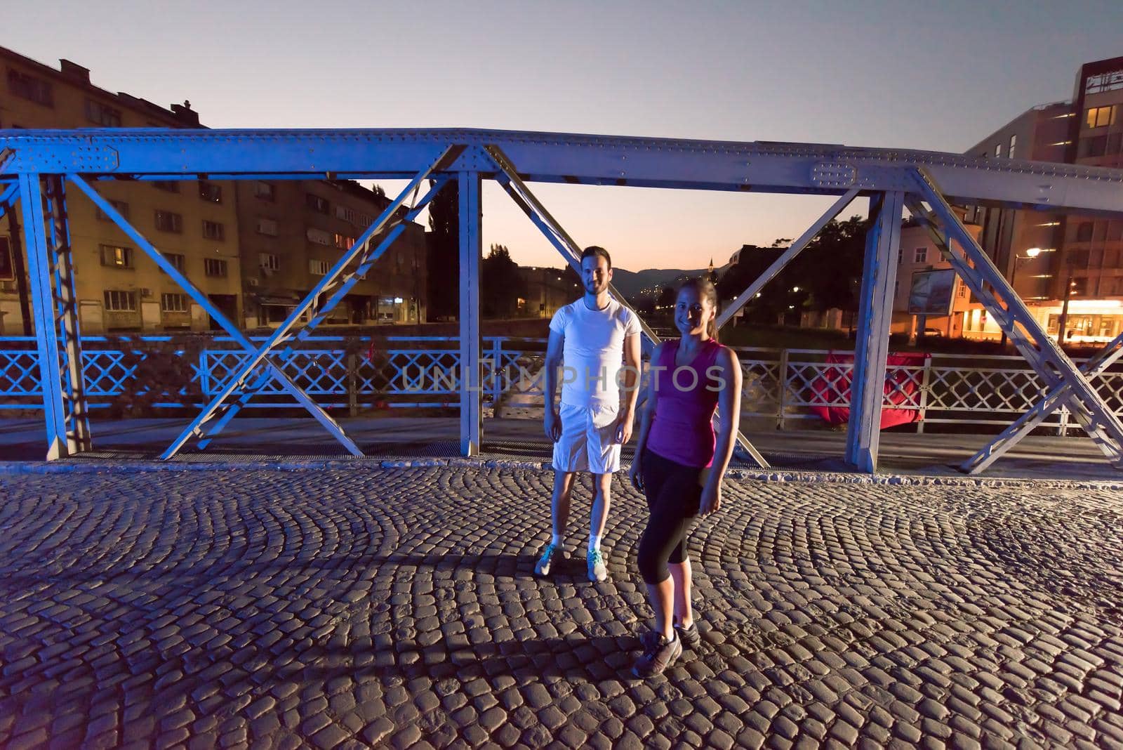 urban sports, healthy couple jogging across the bridge in the city at early morning in night