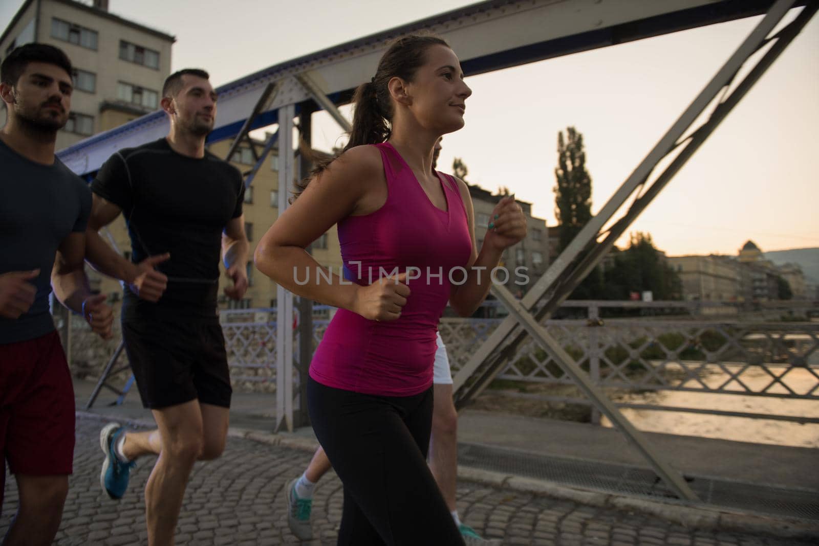 group of young people jogging across the bridge by dotshock