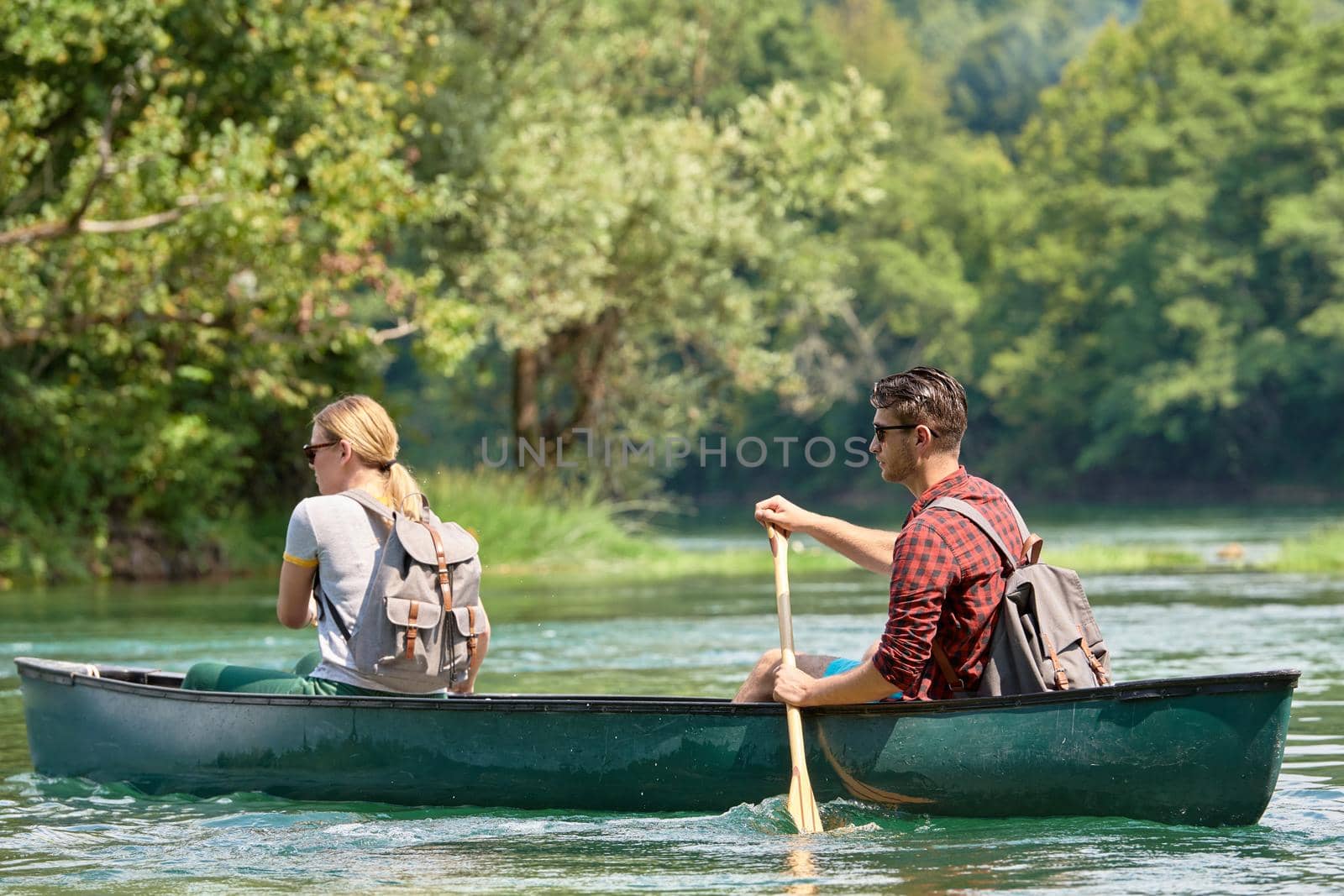 friends are canoeing in a wild river by dotshock