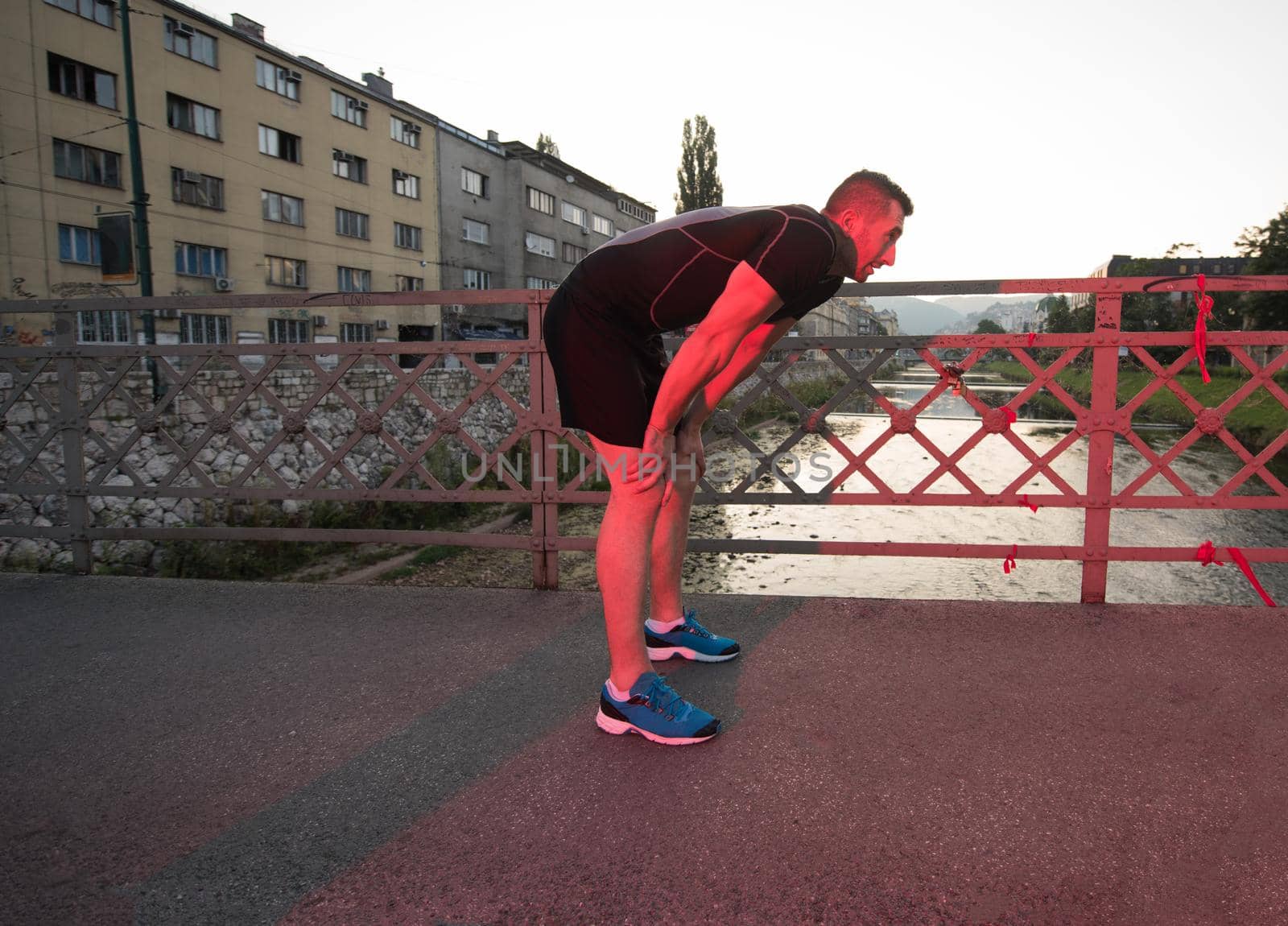 man jogging across the bridge at sunny morning by dotshock