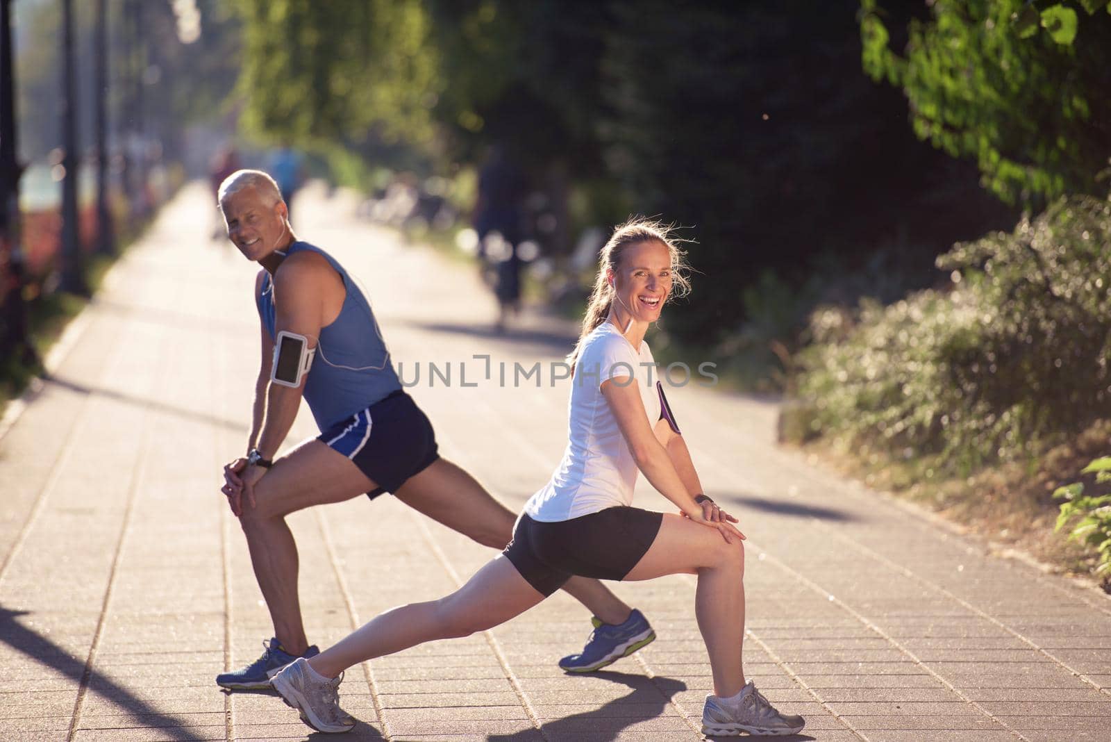 couple warming up and stretching before jogging by dotshock