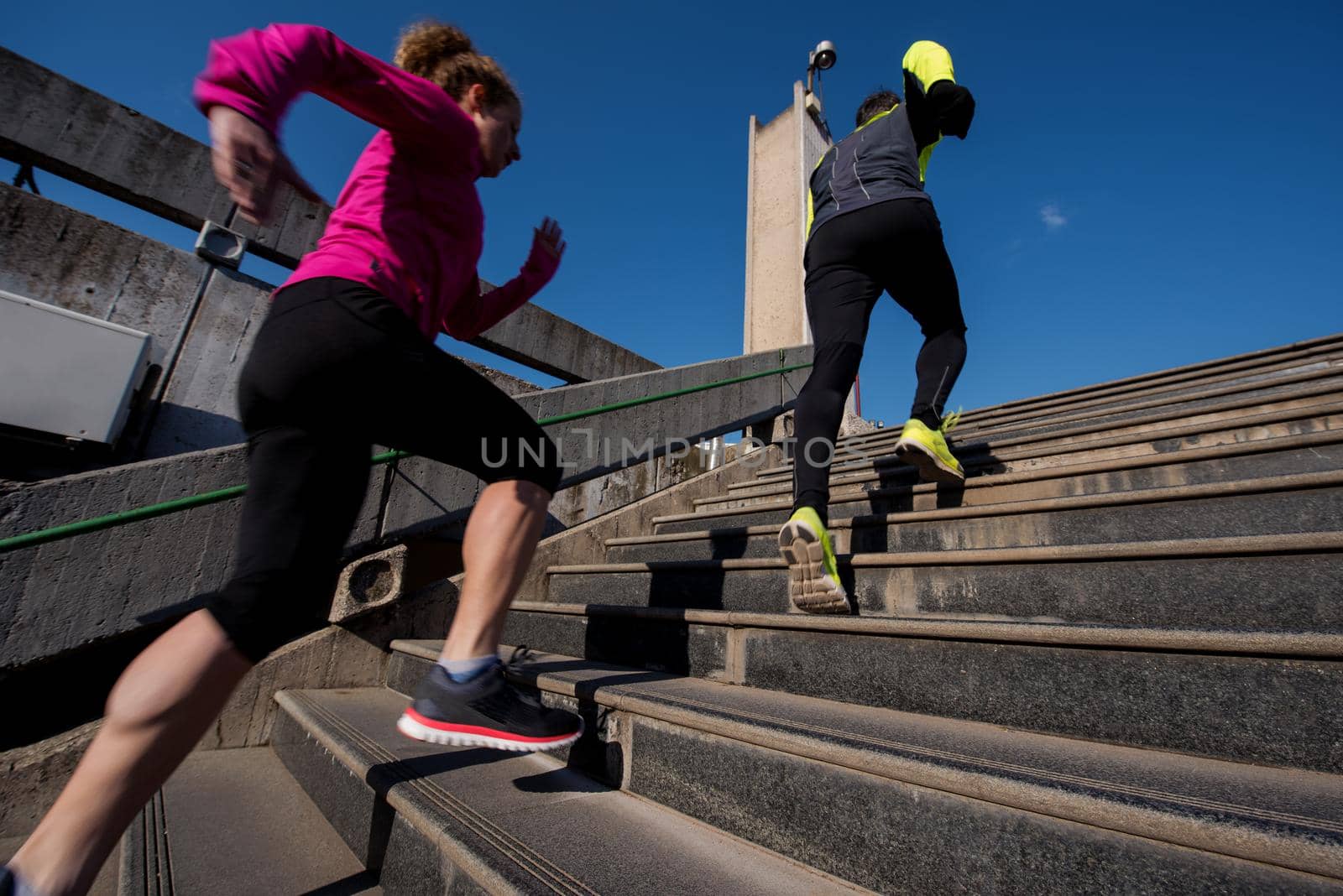 healthy young  couple jogging on steps  at early morning