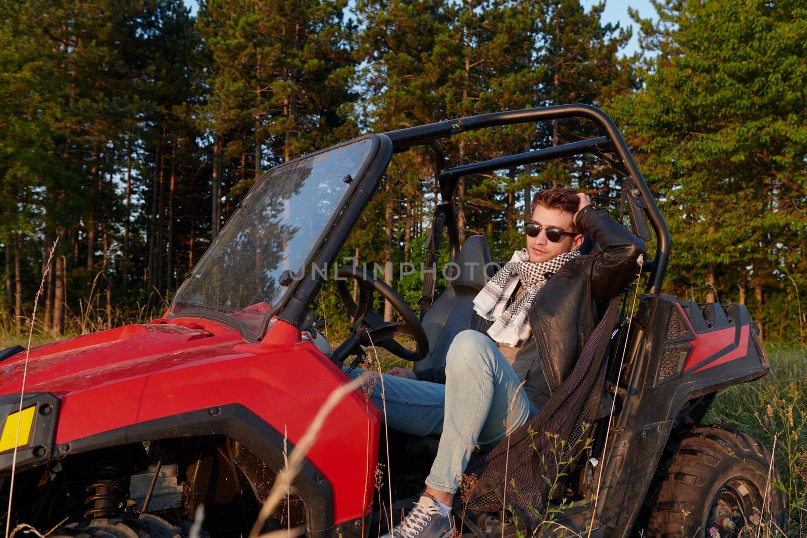 man enjoying beautiful sunny day while driving a off road buggy car by dotshock
