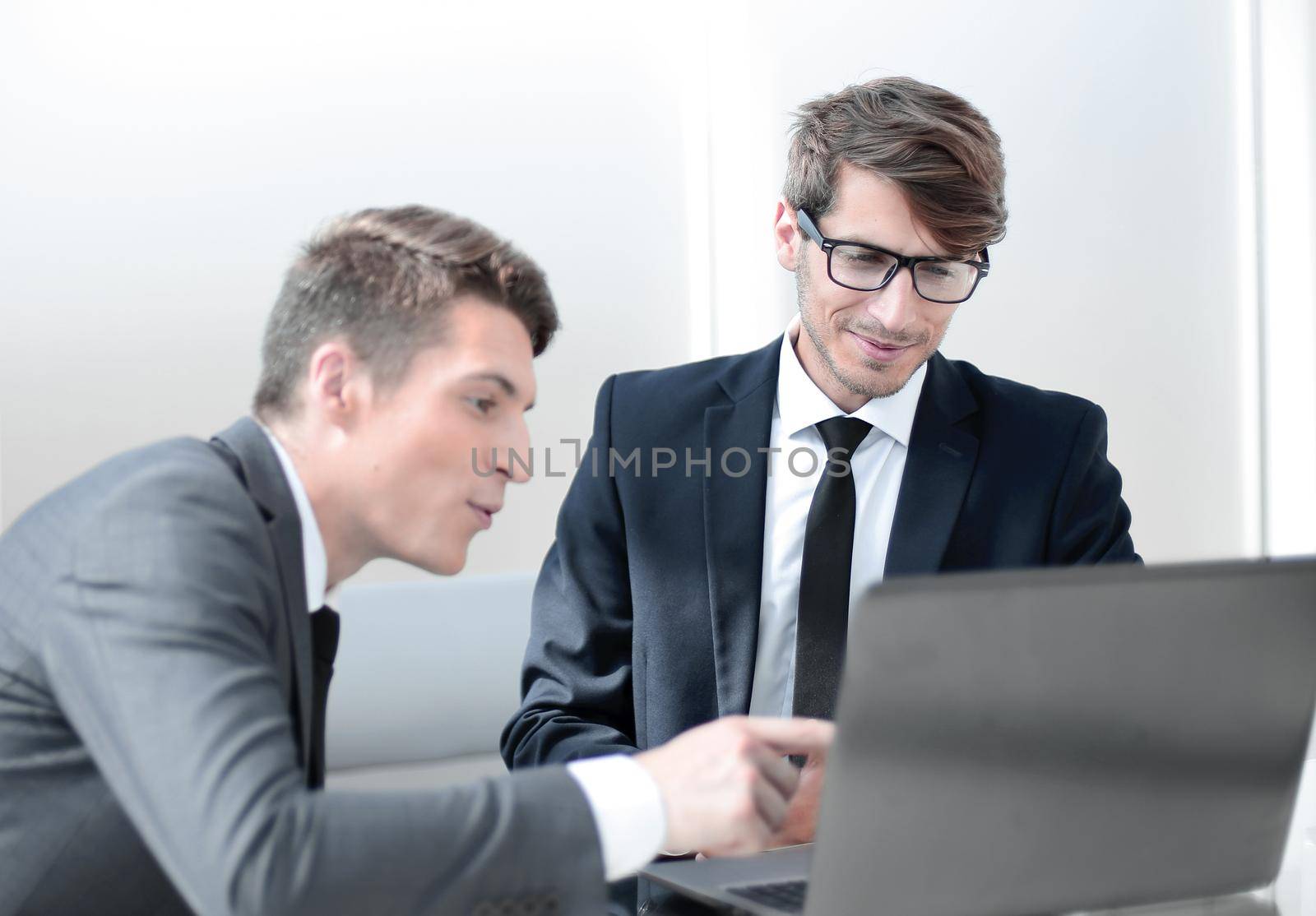 two businessmen looking at a laptop screen. by asdf