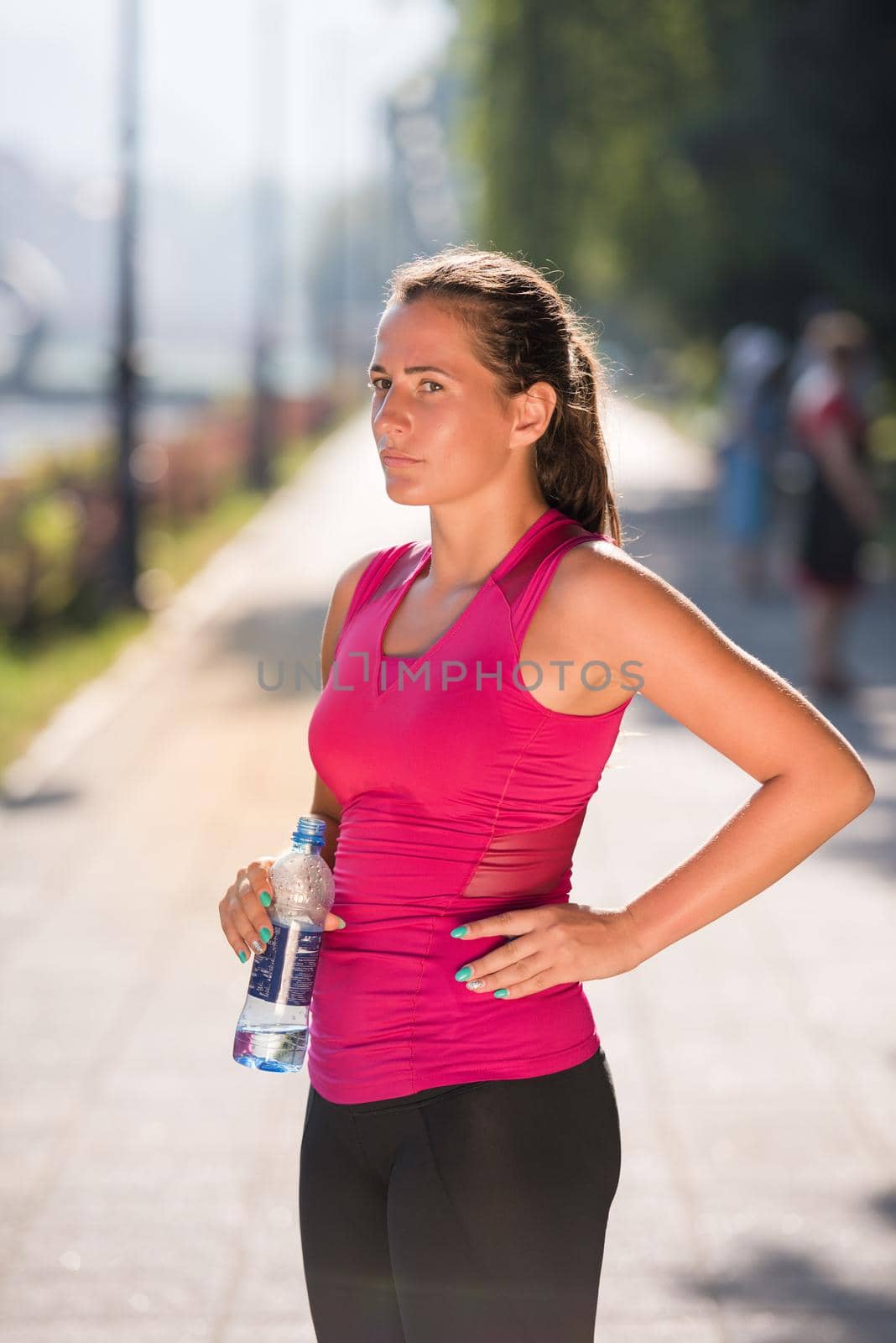woman drinking water from a bottle after jogging by dotshock