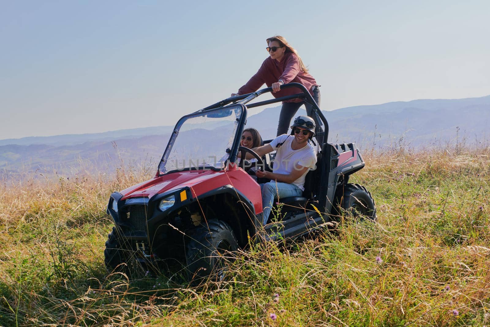 group young happy people enjoying beautiful sunny day while driving a off road buggy car by dotshock