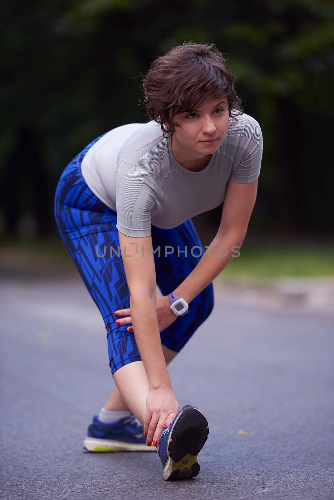 runner   woman warming up and stretching before morning jogging