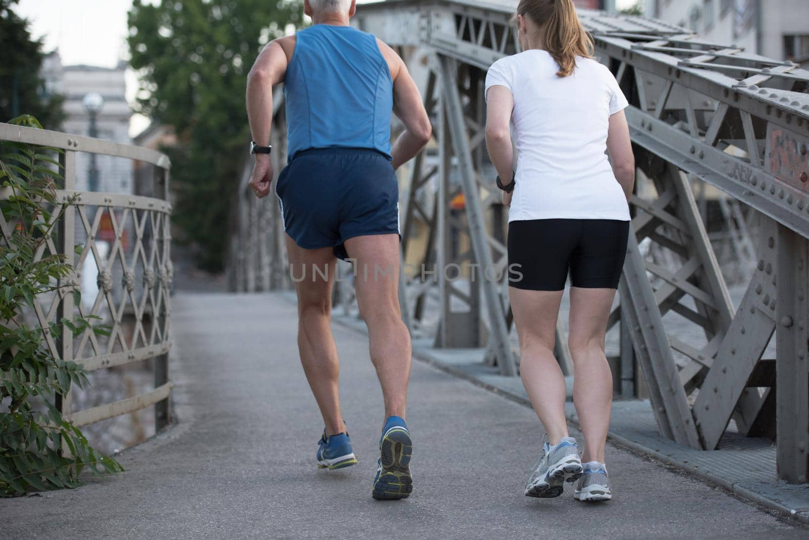 healthy mature couple jogging in the city  at early morning with sunrise in background