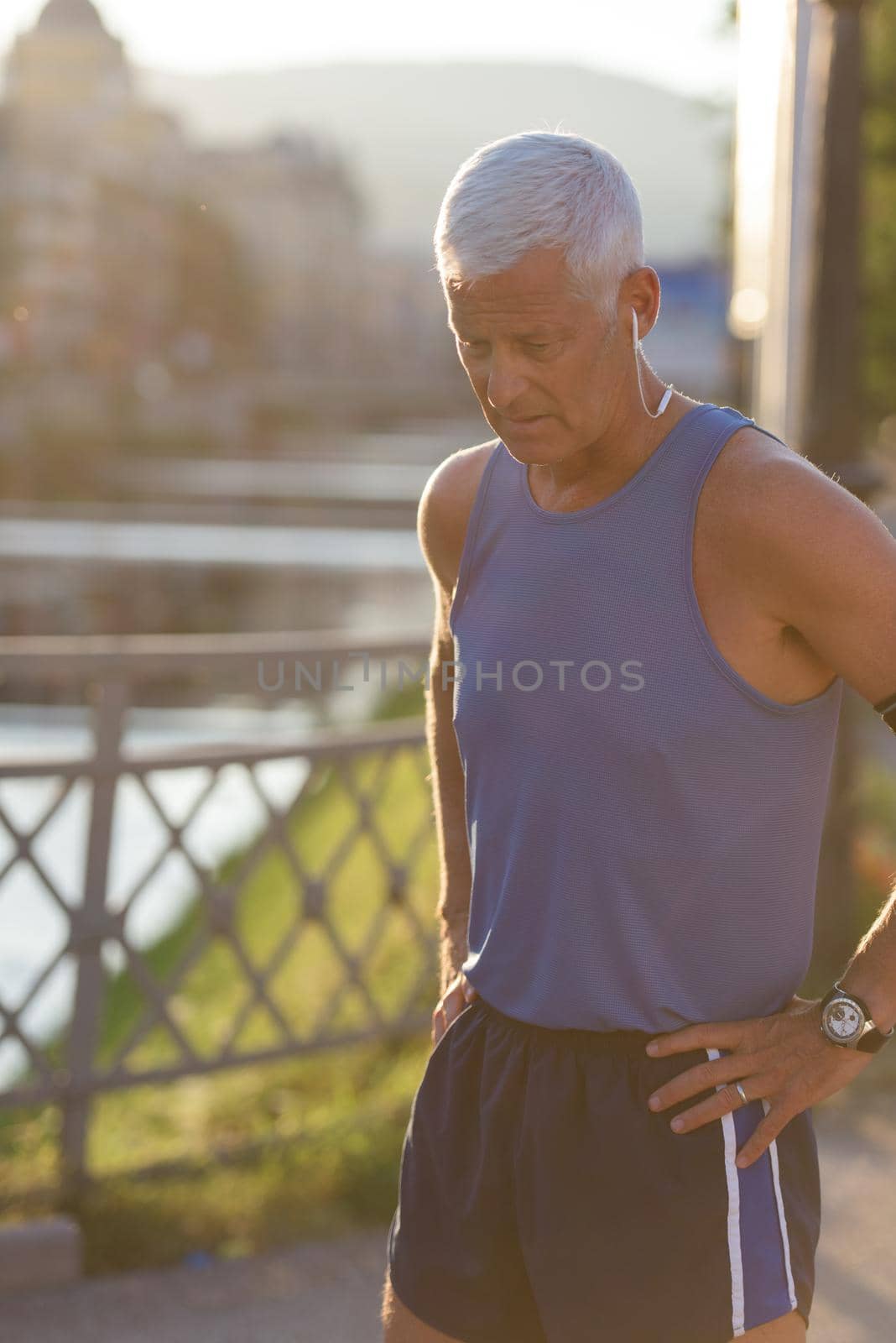 portrait of handsome senior jogging man while relaxing  and take break after morning run