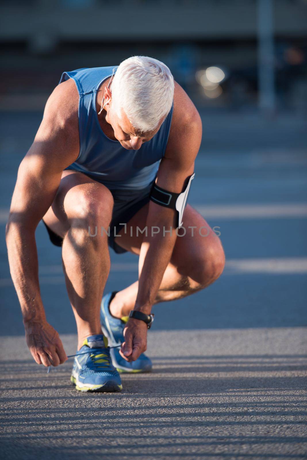 Man tying running shoes laces  before jogging workout