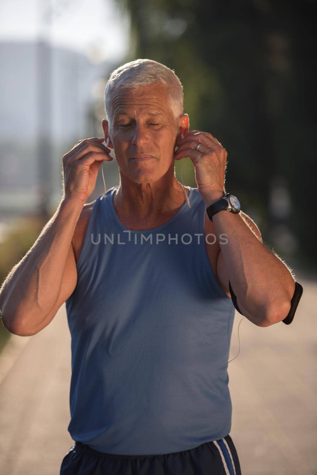portrait of handsome senior jogging man while relaxing  and take break after morning run