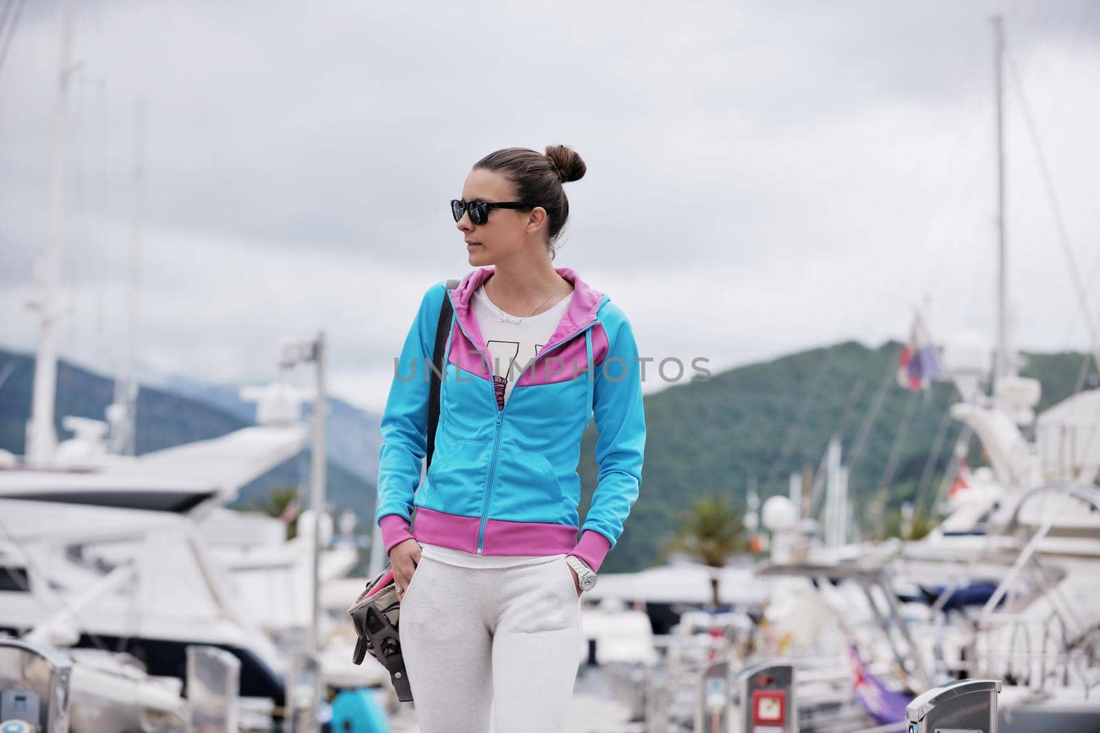relaxed young woman walking in marina by dotshock