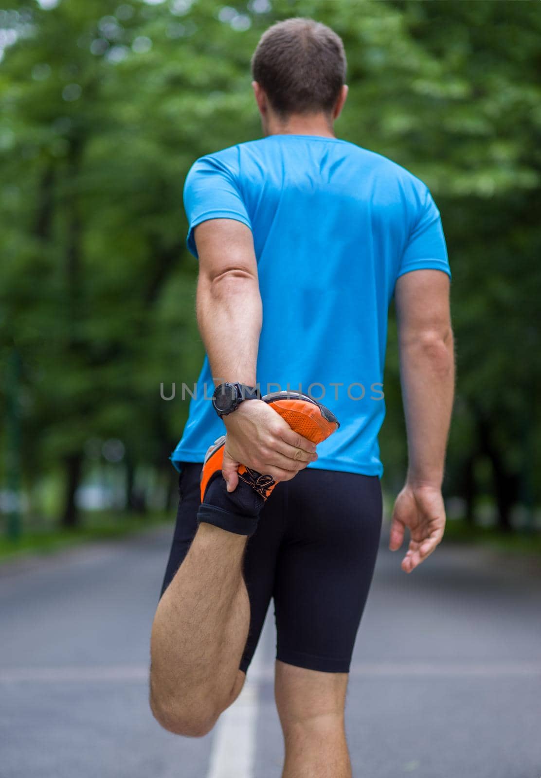 male runner warming up and stretching before morning training by dotshock