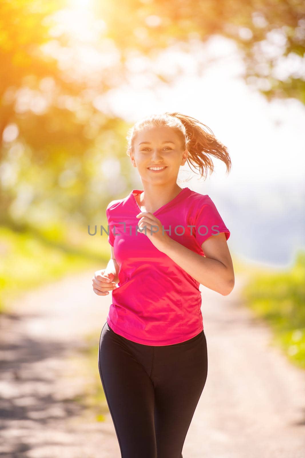 young woman jogging on sunny day at nature by dotshock