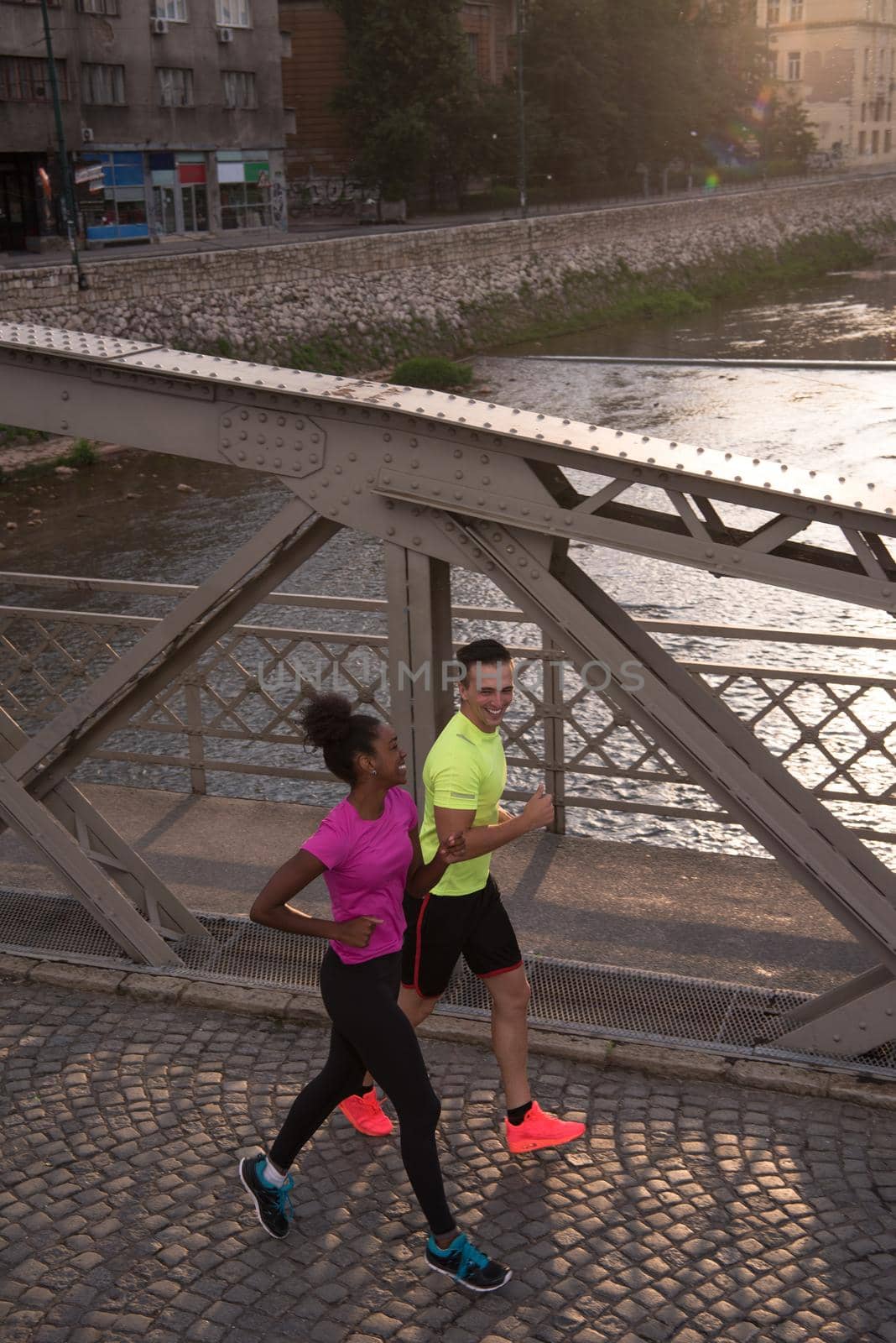 young multiethnic couple jogging in the city by dotshock