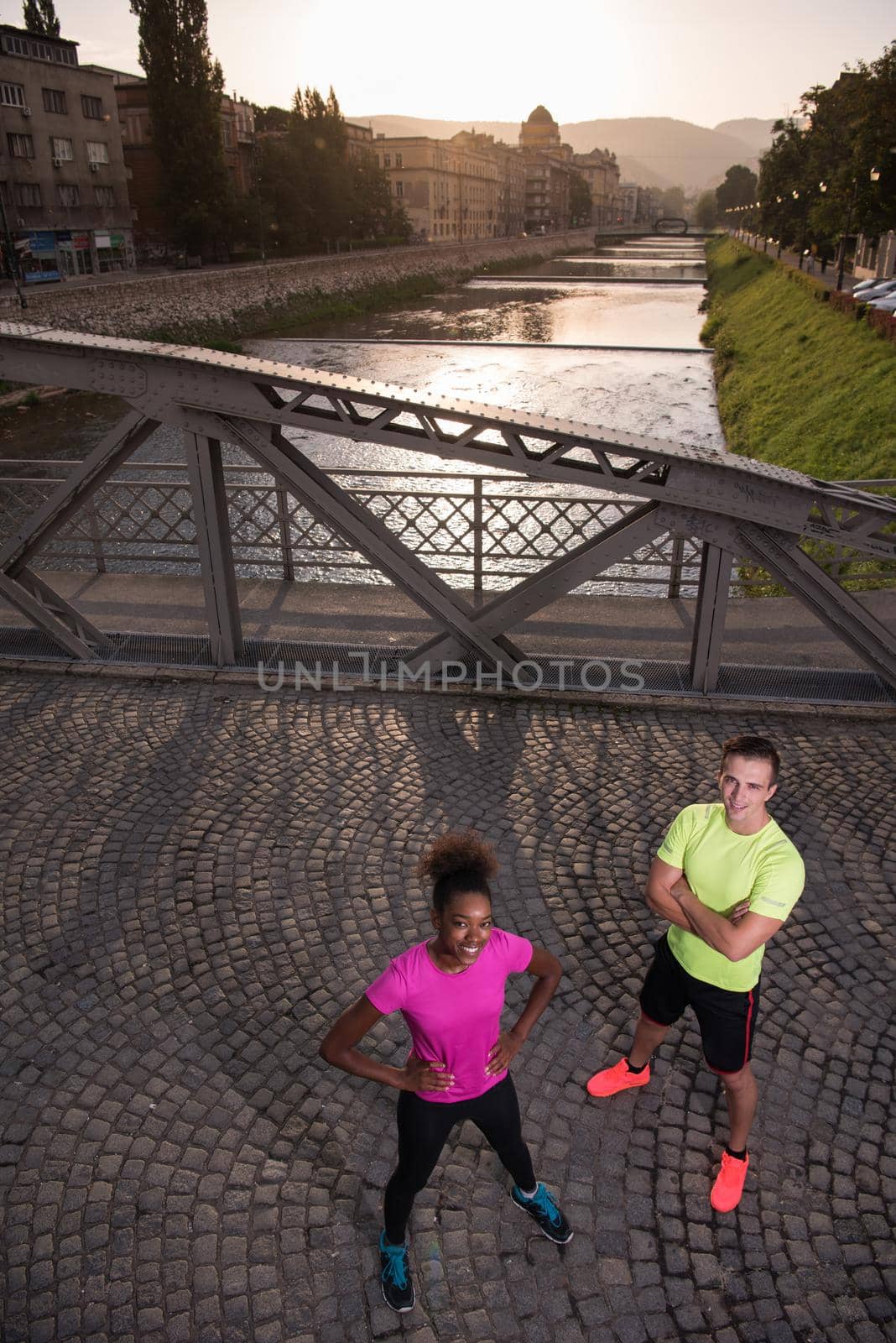 portrait of a young multiethnic couple jogging in the city by dotshock