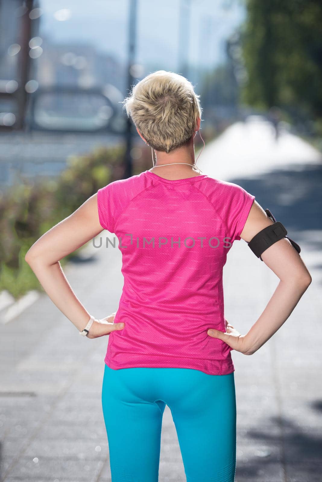 jogging woman setting music and running route on  smart phone putting  earphones before morning run