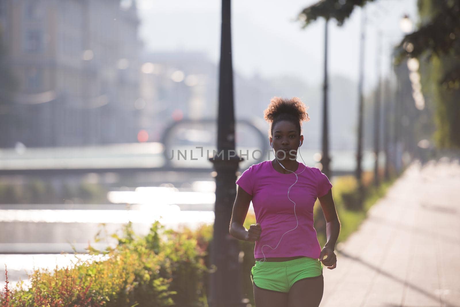 african american woman jogging in the city by dotshock