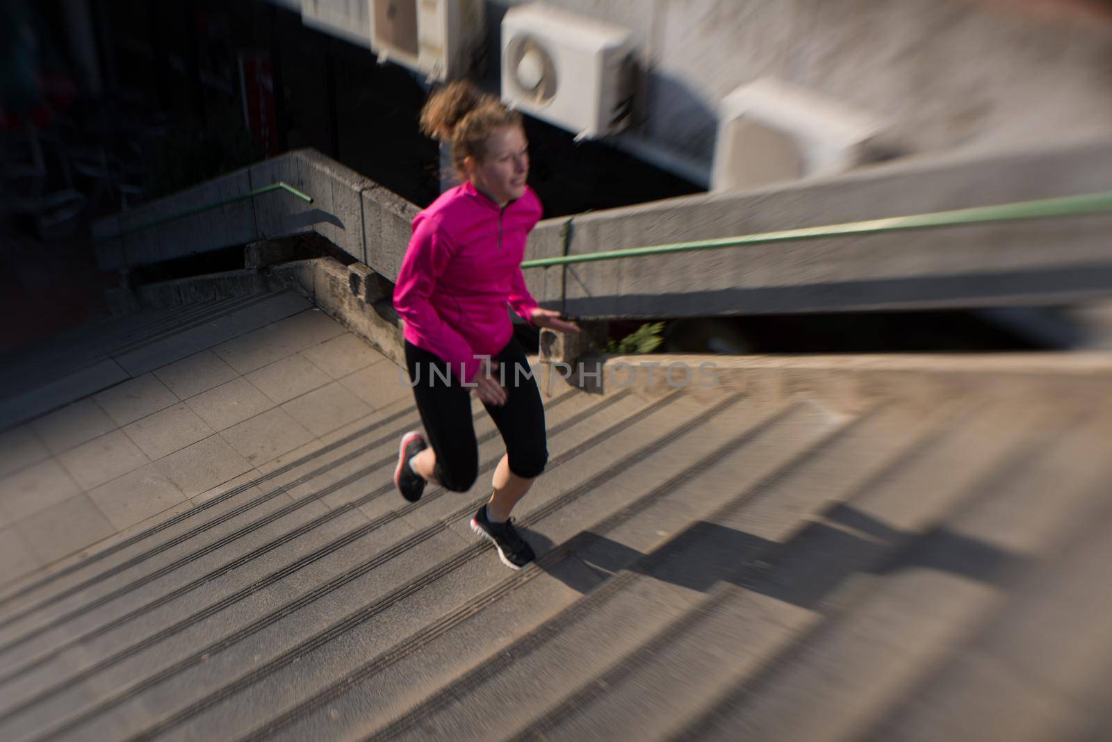 sporty woman running onsteps at early morning jogging