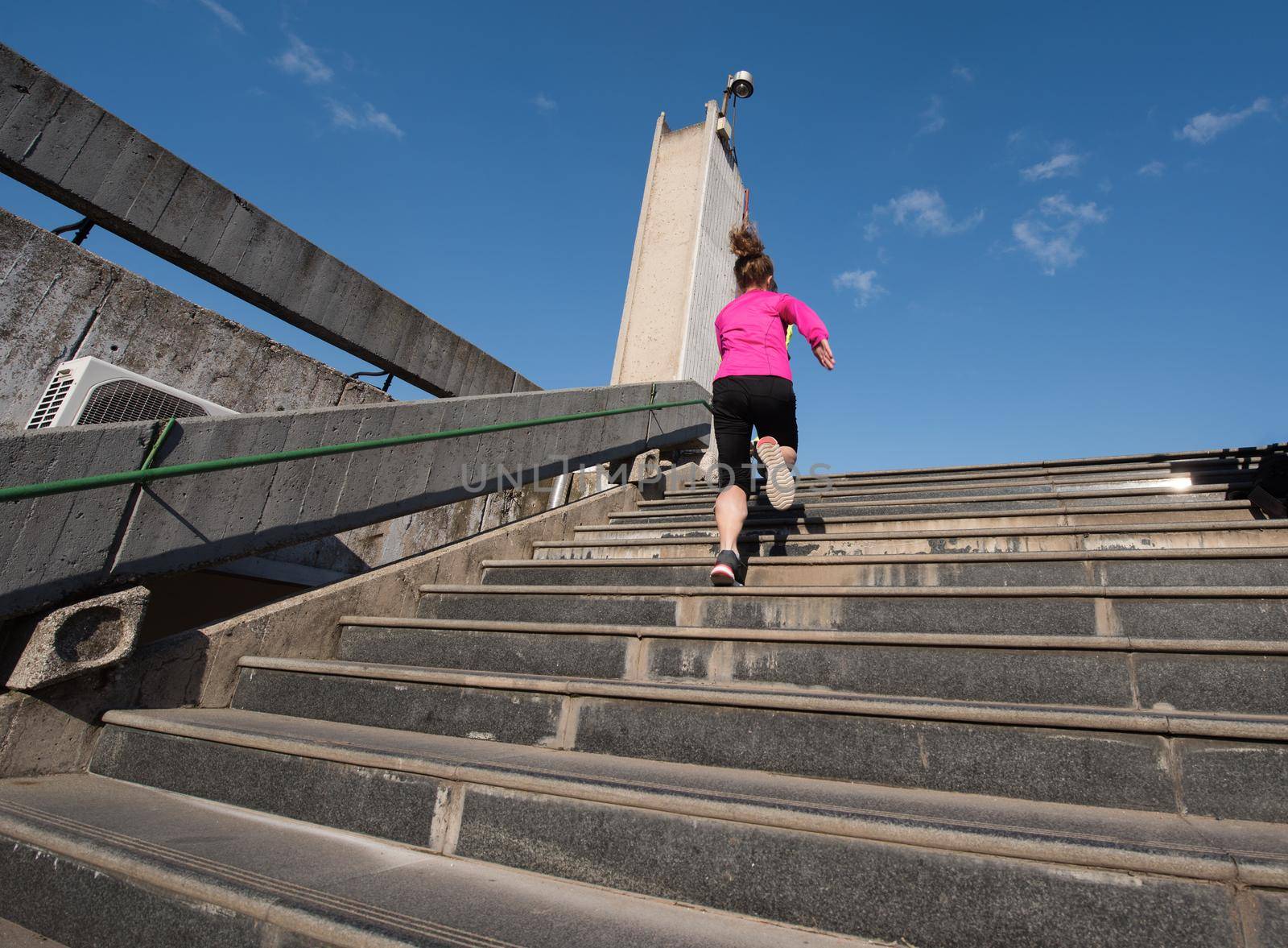 sporty woman running onsteps at early morning jogging