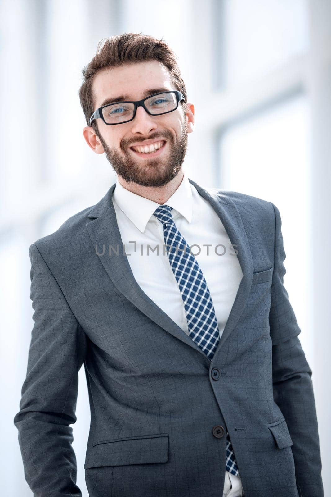 smiling businessman on the background of the office by asdf