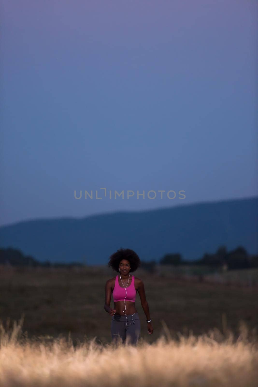 Young African american woman jogging in nature by dotshock